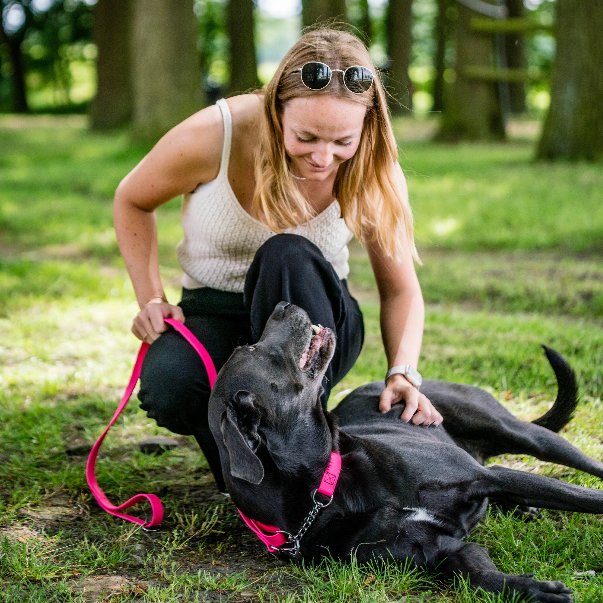 Frau und schwarzer Hund mit pinken Biothane Halsband und pinker Biothane Hundeleine