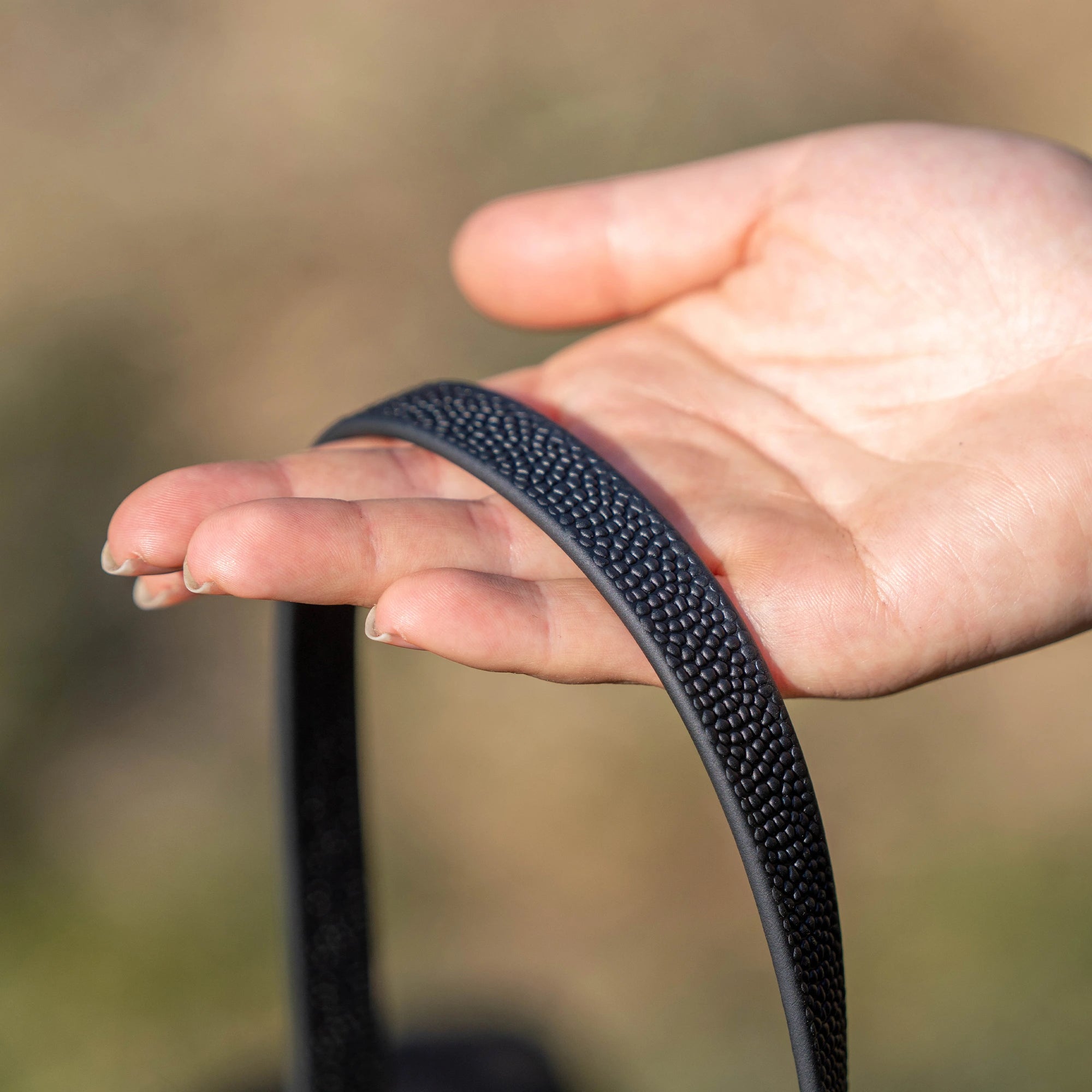 schwarze Footballgrip Biothane Leine auf der Hand