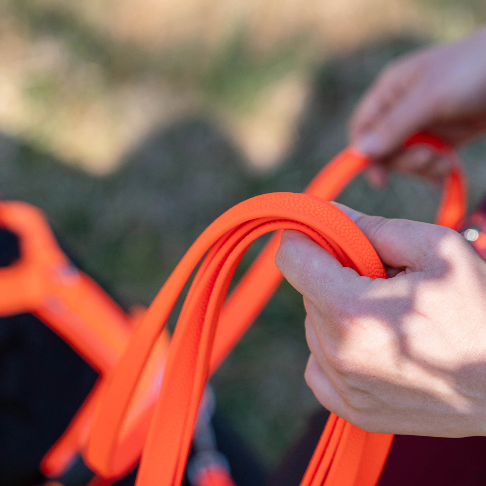 orangene Footballgrip Biothane Leine in der Hand