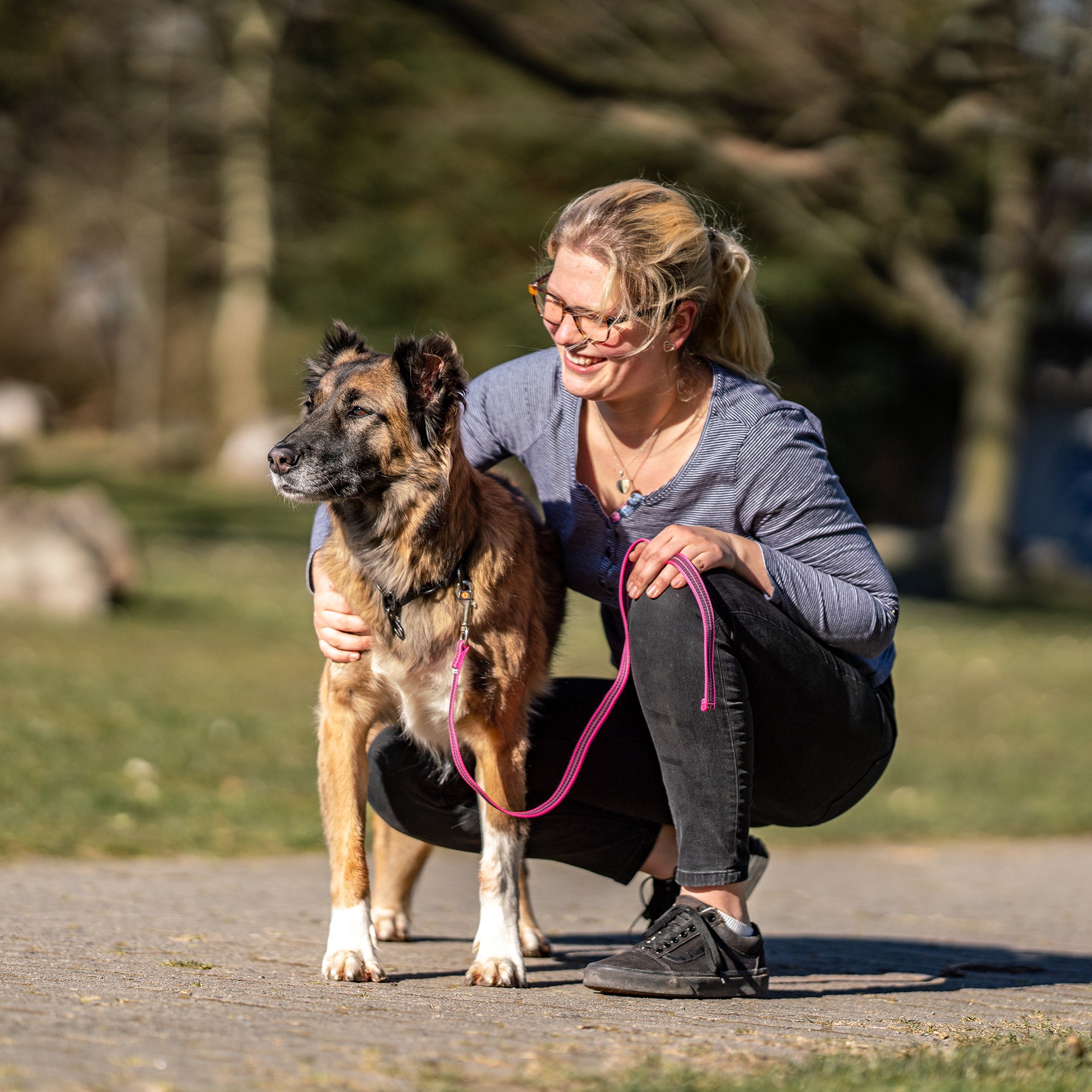 Frau und Hund mit pinker Kurzleine