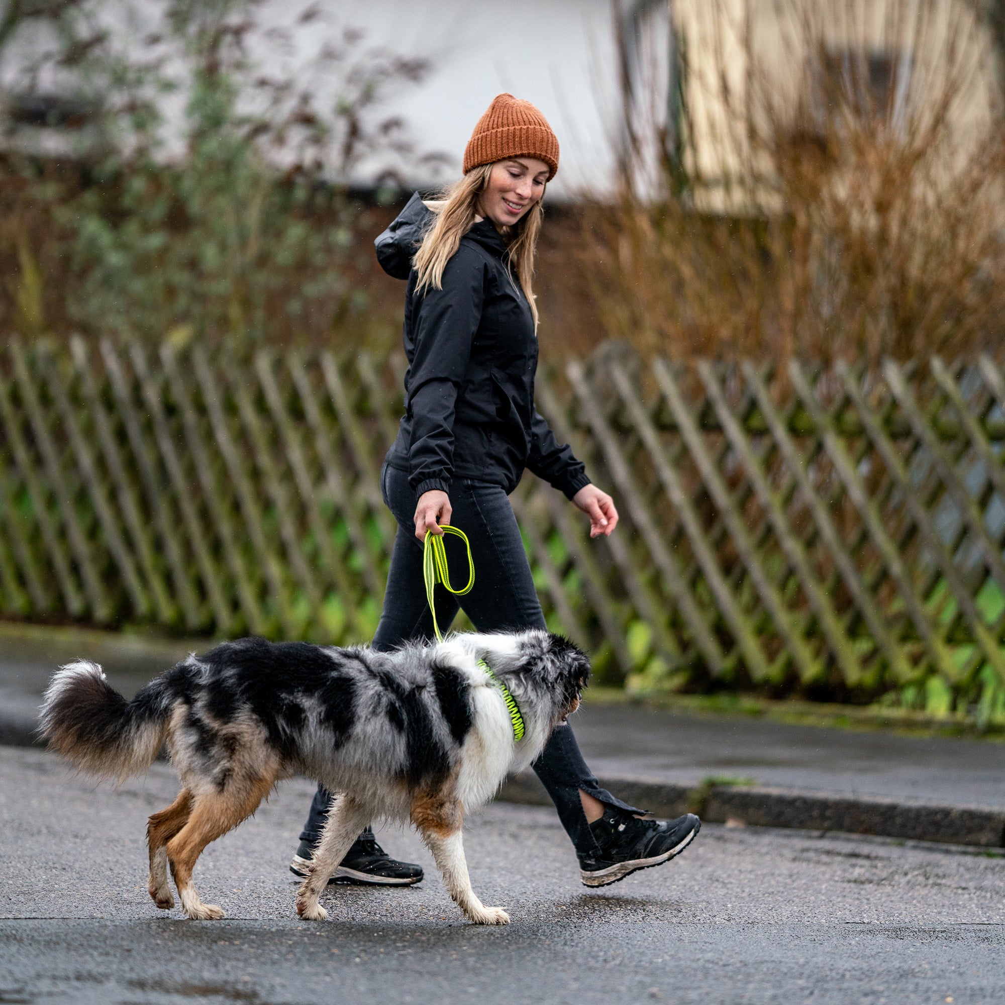 Frau und Hund mit neongelben Paracord Halsband und Leine beim spazieren gehen